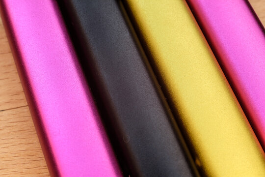 multi-colored aluminum rods, parallel to each other, close-up photo