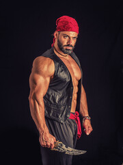 Muscular male pirate in studio shot, wearing bandana and open vest