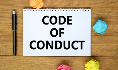 Code of conduct symbol. Words 'Code of conduct' on beautiful wooden table, colored paper, black...