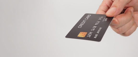 Black credit card in hand isolated on white background.