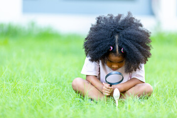 African girl with afro hair sitting watching mushrooms studying nature Concept of learning the...