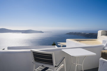 Chair and table on terrace of luxury hotel. View of caldera. Santorini island, Greece. Volcano....