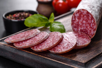Spanish dried sausage salami on a dark concrete background