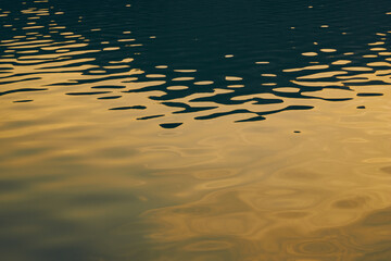 Abstract background water surface reflecting the sun. Wallpaper with waves form ripples