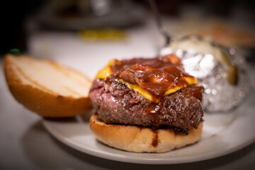 A juicy and appetizing burger with crispy bacon and melted cheese and dripping sauce