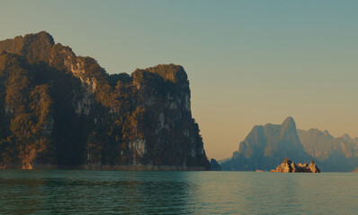 Naklejka premium Cheow Lan lake in Khao Sok National Park, Thailand. Tropical landscape at the dawn postcard poster wallpaper