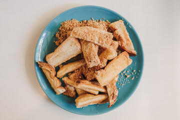 Dusty toast sticks with barbecue flavor powder served on blue ceramic dish.