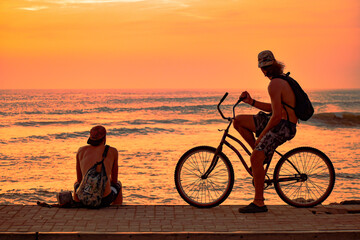 Fototapeta na wymiar Two friends watching the sunset after a day of surfing