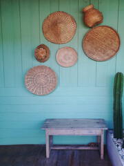 Pastel green wall and wooden hat in thai styke  on green wall with  woodenoard, copy space on empty wall
