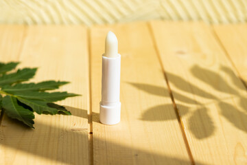 hygienic lipstick on a wooden background in a white case