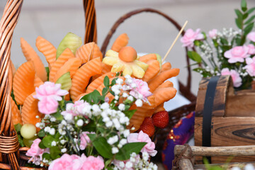 closeup of an edible fruit arrangement setup in a basket with flowers