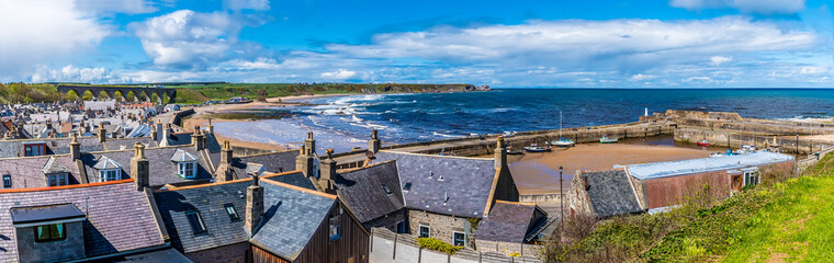 A view across the roof tops and the beach of the town of  Cullen, Scotland on a summers day