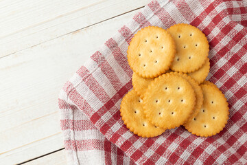 Cracker cookies with tablecloth on white wooden table background.