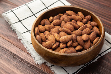 Almonds in wooden bowl on the table, Healthy snack, Vegetarian food.
