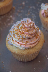 Cupcake with pink purple frosting and gold sprinkles