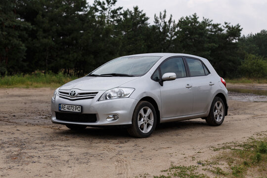 Dnipro, Ukraine - July 30, 2021: Toyota Auris 2012 silver color in the city near the forest. Summer rain
