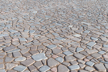 Paving stones made of natural stone on the road, background.