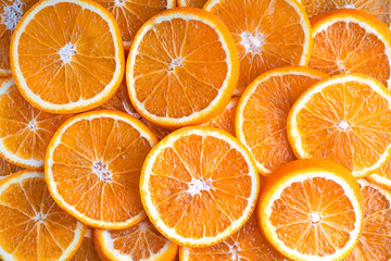 Background made of fresh juicy ripe sweet orange fruit slices commonly peeled and eaten fresh or squeezed for juice containing vitamin C, dietary fiber and minerals suitable for vegans. Horizontal