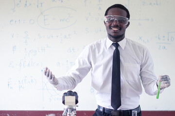 African scientist teacher is  holding  test tube with chemical liquid.Black man is teaching science classes with using microscope in the classroom.Concept of Happy teacher`s day