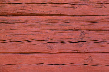 Front view close-up of an old, weathered and aged wooden wall painted in red. Abstract full frame textured background.