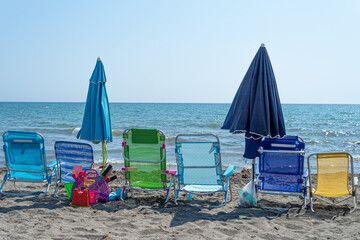 Colorful deck chairs on the beach by the sea. Summer and holidays concept