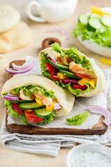 Pita with roasted chicken and vegetables: cucumber, tomato, pepper, red onion and yoghurt sauce. Healthy food. Selective focus 
