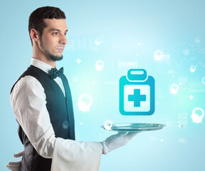 Handsome young waiter in tuxedo holding healthcare icons on tray