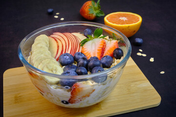 Healthy breakfast with fresh fruits. Bowl of colourful fruits and oaats.