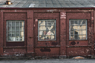 Three windows of an old factory on Oktyabrskaya street