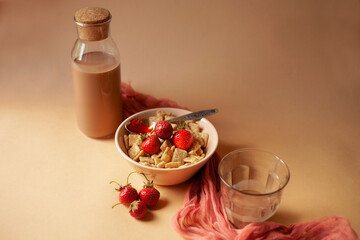 Cereals in apricot bowl with fresh strawberry for breakfast on soft linen background