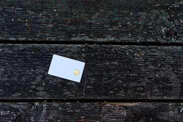 Bank card on a wooden table in nature. The concept of payment for nature.