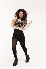 Glamorous model girl in fashionable clothes and trendy sunglasses walking over white background, isolated studio fashion portrait