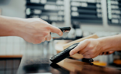 NFC payment online from your phone. An employee sells coffee in a paper cup or takeaway food.