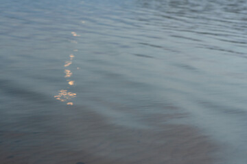 reflected sun rays on sea water. Glare on the water Natural abstract background of sea water..