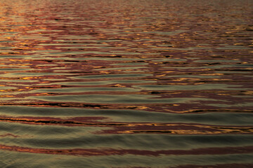 reflected sun rays on sea water. Glare on the water Natural abstract background of sea water..