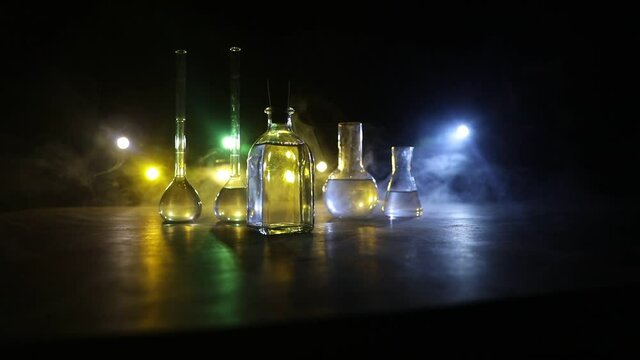 Pharmacy and chemistry theme. Test glass flask with solution in research laboratory. Science and medical background. Laboratory test tubes on dark toned background , science research equipment concept