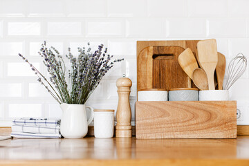 kitchen details, wooden tray with cutting board and ceramic jars on wooden table, white ceramic...