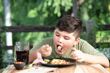 Niño latinoamericano, mexicano, sinaloense comiendo mariscos tostada de camaron acompañado con agua fresca