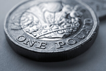 1 one British pound coin close-up. Grey tinted background about economy, business, finance or banking. Backdrop from Britain's money. Coins of England. Classic gray color. Macro