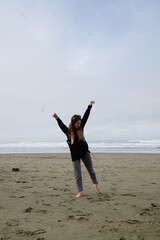 Girl on the sandy beach. A girl in a black jacket on the seashore.