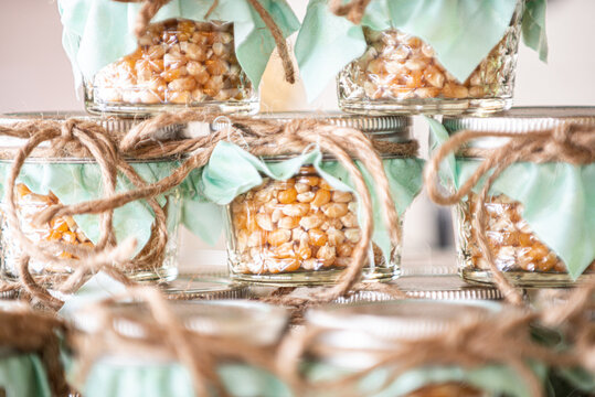 Popcorn kernels stacked in glass jars with green tops  at dessert bar