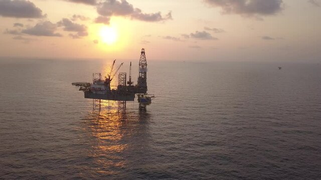 Aerial view of the jack up rig shot during sunset time. Fly around the jack up rig with a drone.
