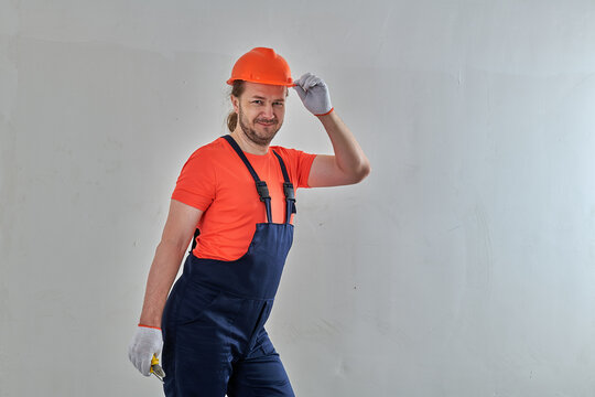 orange hard hat repair master stands against white wall background