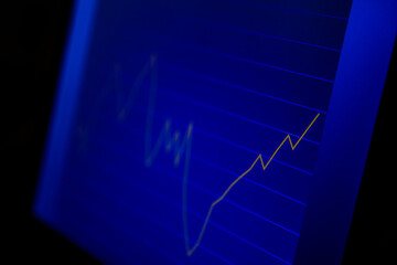 Naklejka premium Macro closeup of blue screen with growing line graph