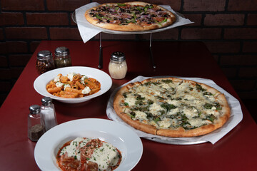 Buffet of food on the table family style with the vegetarian pizza featured as the centerpiece
