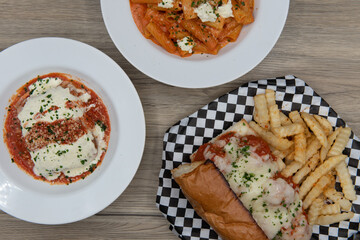 Buffet of food on the table family style with the meatball sub sandwich and fries  featured as the...