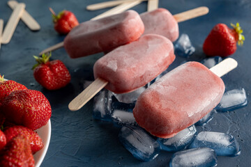 Strawberry and banana popsicles on dark blue background, Homemade ice cream.