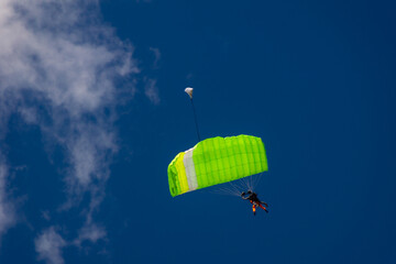 tandem parachute jump, beginner with an instructor hover under a green canopy