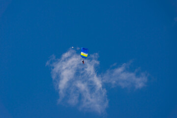 Naklejka na ściany i meble blue paraglider soars against a background of blue sky and clouds