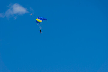 Naklejka na ściany i meble tandem parachute jump, a beginner with an instructor land under the canopy of a parachute